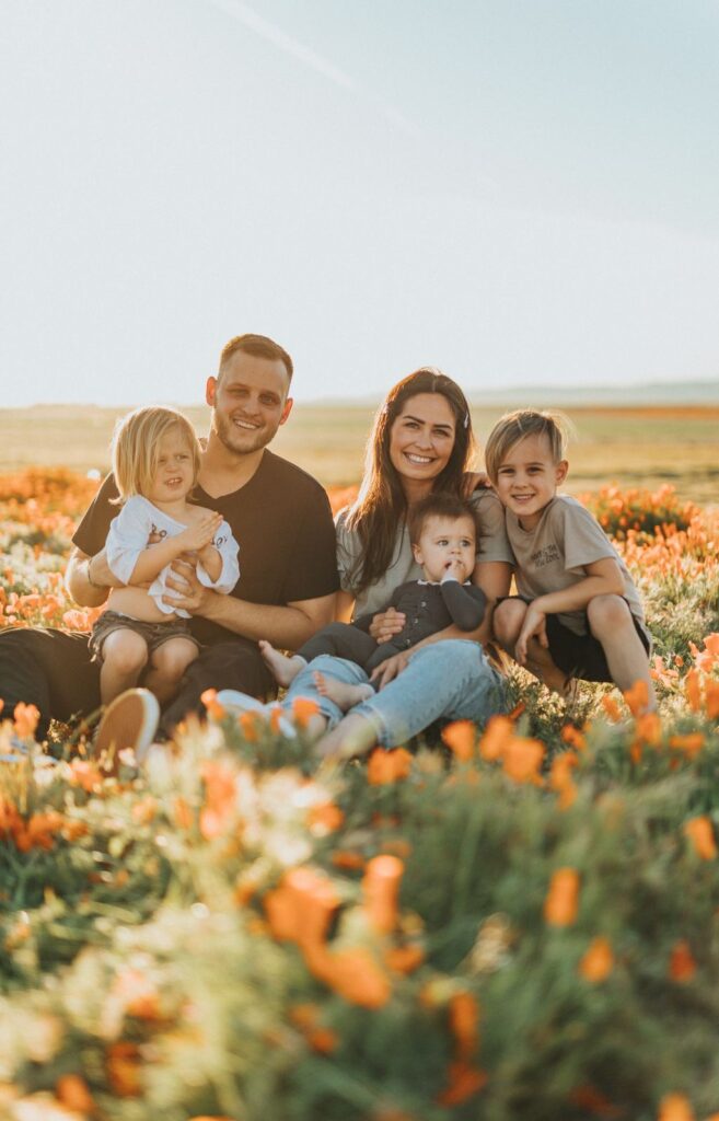 Family sitting together in a field of flowers in Guelph